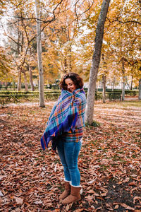 Full length of woman standing in park during autumn