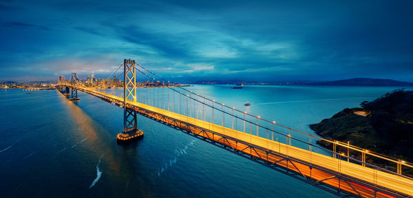 Suspension bridge over sea against sky