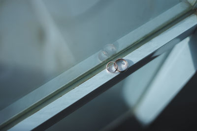 High angle view of wedding rings by window