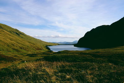 Scenic view of sea and mountains against sky