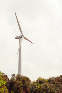 Low angle view of windmill on field against sky