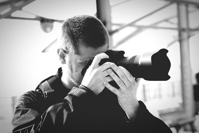 Man photographing through dslr while standing outdoors