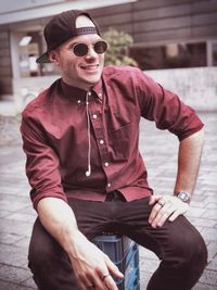 Man wearing sunglasses sitting on crate