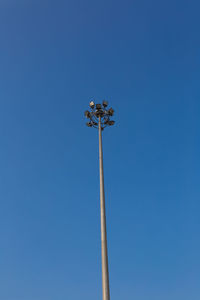 Low angle view of floodlight against blue sky