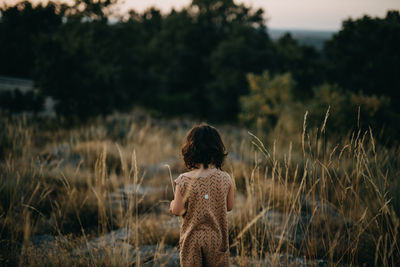 Rear view girl standing on the fields