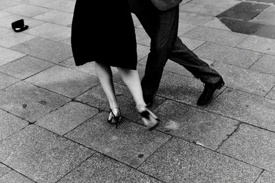 Low section of man and woman dancing on footpath