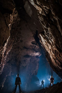 Mid adult man climbing standing in cave
