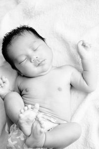 High angle view of baby lying on bed