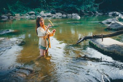 Full length of woman with reflection in lake