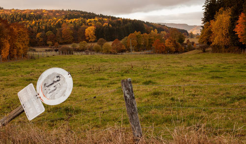 Information sign on field against sky during autumn