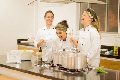 Female chefs laughing while having champagne in commercial kitchen