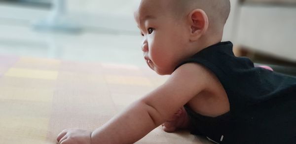 Side view of cute boy looking away at home