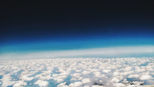 Aerial view of clouds over snow covered landscape