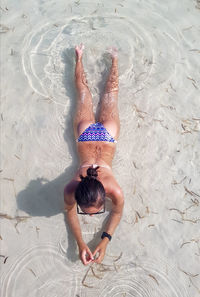 High angle view of woman in bikini lying on beach