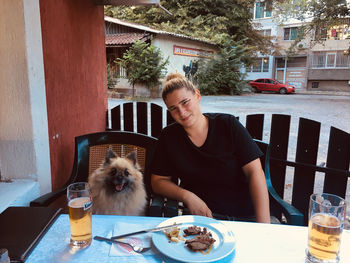 Portrait of woman with dog on table