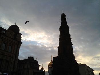 Silhouette of church against cloudy sky