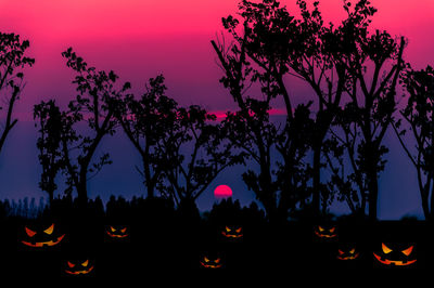 Silhouette trees against sky at night