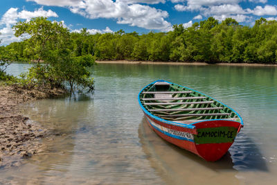 Boat moored in lake against sky