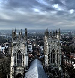 Aerial view of cathedral against cloudy sky in city