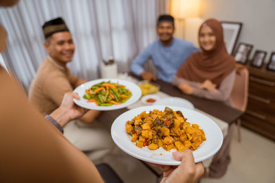 Midsection of woman serving food at home