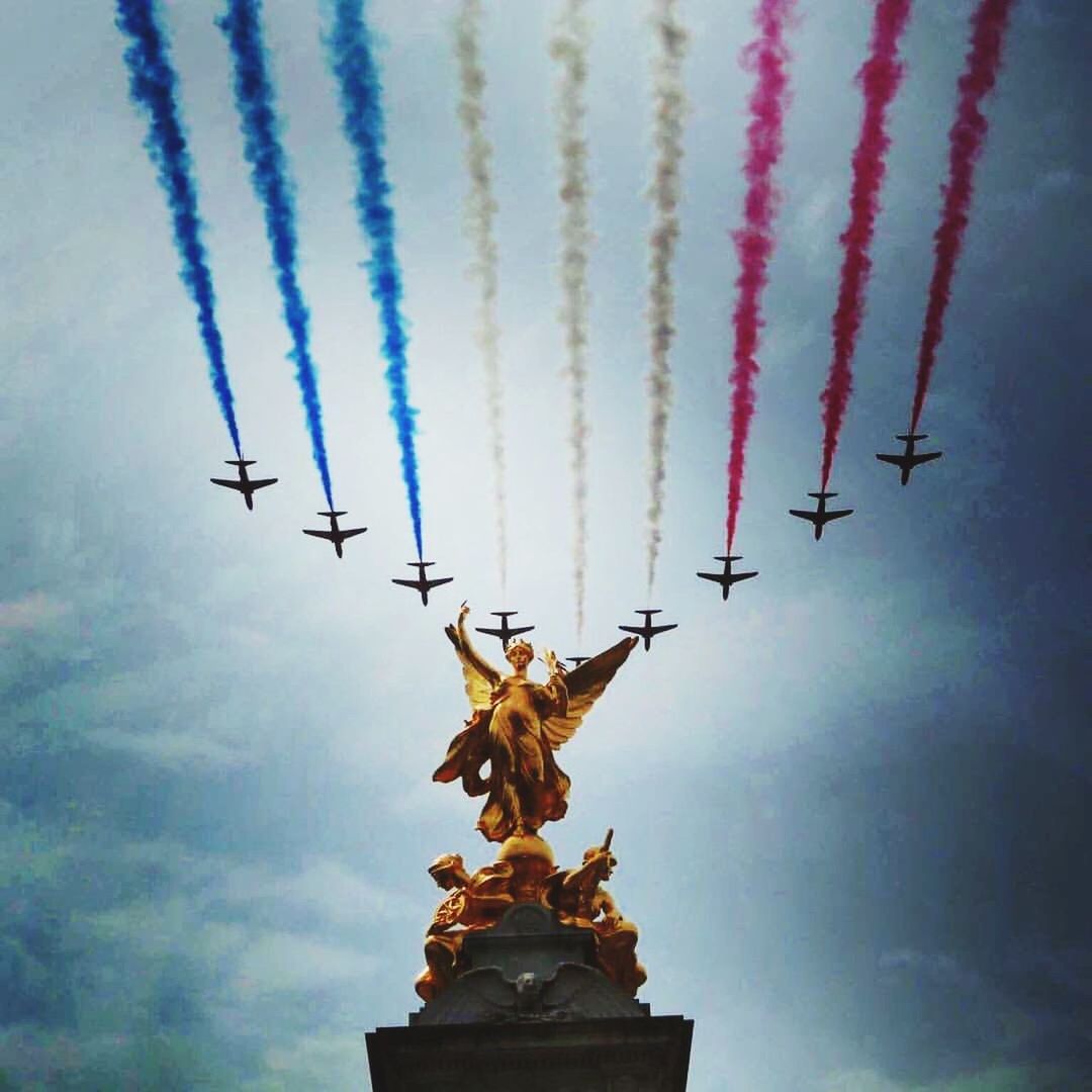 LOW ANGLE VIEW OF STATUE AGAINST VAPOR TRAILS IN SKY