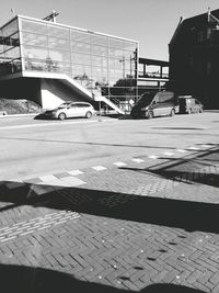 Cars on street by buildings against sky