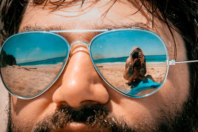 Close-up of man wearing sunglasses at beach