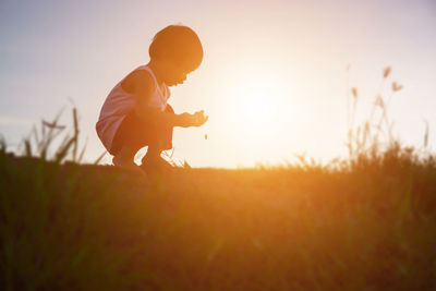 Side view of man on field against sky during sunset