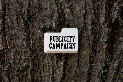 Close-up of information sign on tree trunk