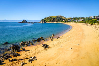 Scenic view of beach against clear blue sky