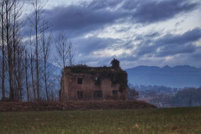 Abandoned house on field against sky