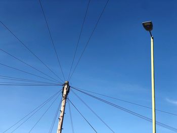 Low angle view of electricity pylon against clear sky