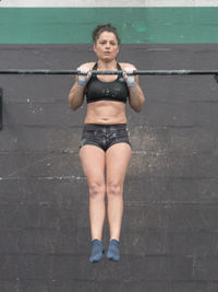 Full length portrait of young woman standing outdoors