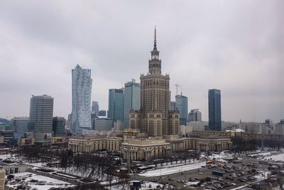 Palace of culture and science in city against sky during winter