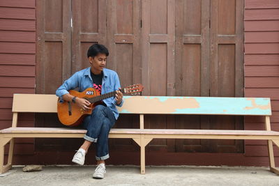 Full length of man playing guitar