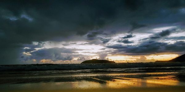 Panoramic view of sea against dramatic sky during sunset