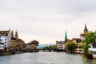 River amidst buildings in city against sky