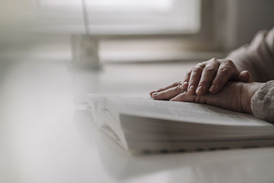 Close-up of senior woman reading book on table