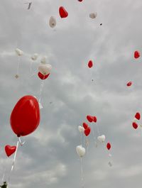 Low angle view of balloons flying against sky