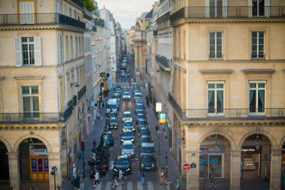 People walking on street amidst buildings in city