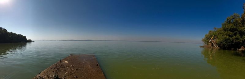 Scenic view of lake against clear blue sky