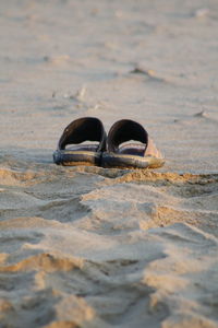 Close-up of flip-flops on sand