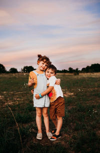 Full length of mother and daughter on field during sunset