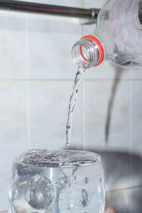 Close-up of drink pouring water in glass