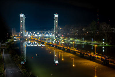 Railway bridge reflecting on the water surface in the canal in the evening