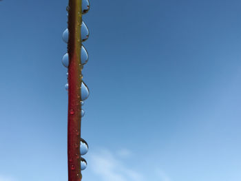 Low angle view of hanging light against clear blue sky