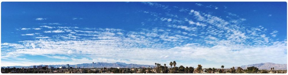 Panoramic shot of cityscape against blue sky