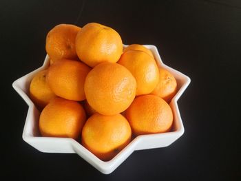 Close-up of lemons in container against black background