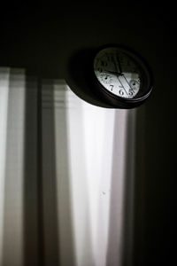 Low angle view of clock on window