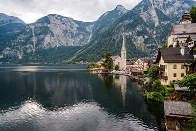 Buildings by lake against mountain
